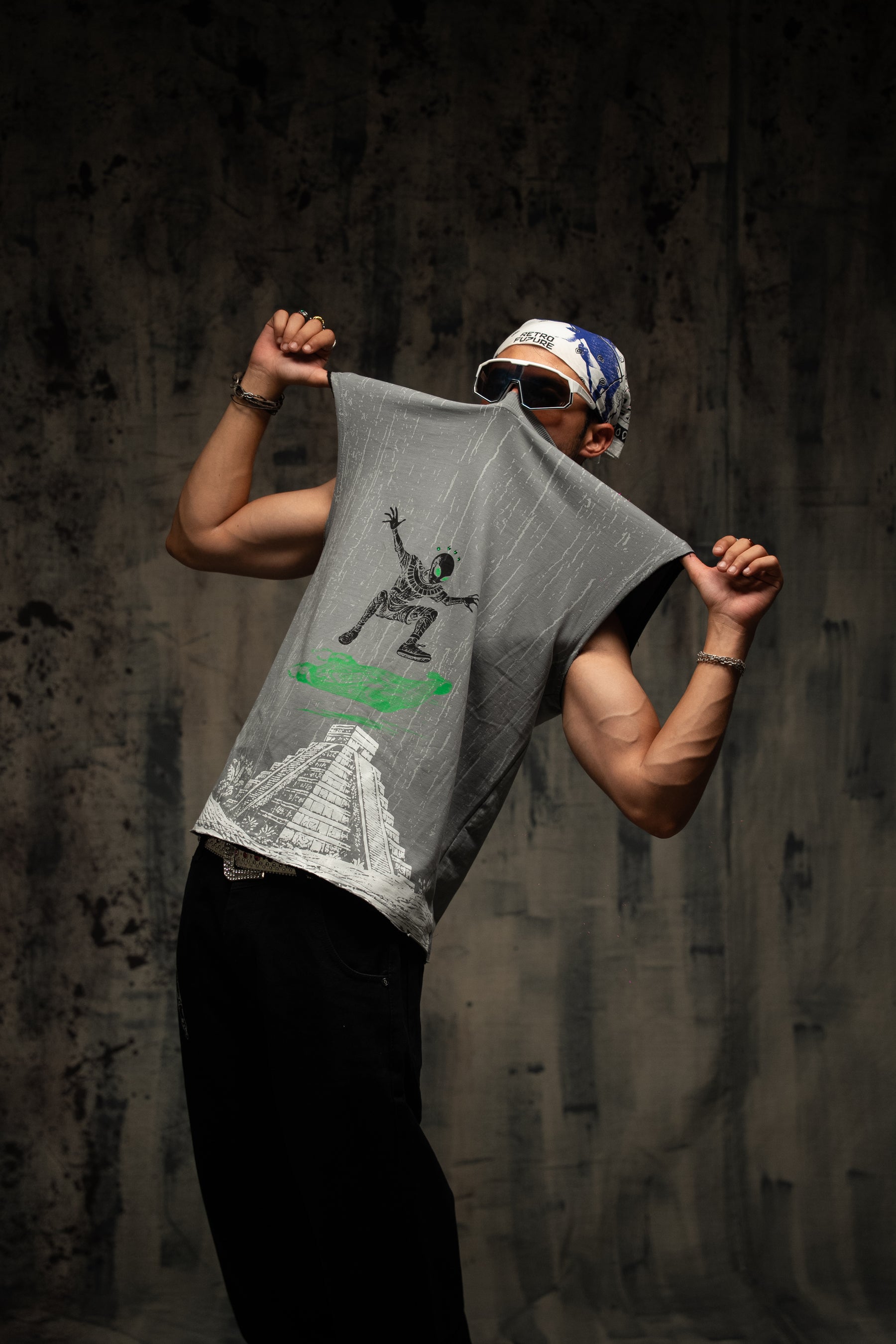 Person holding a gray t-shirt with graphic design against a dark background