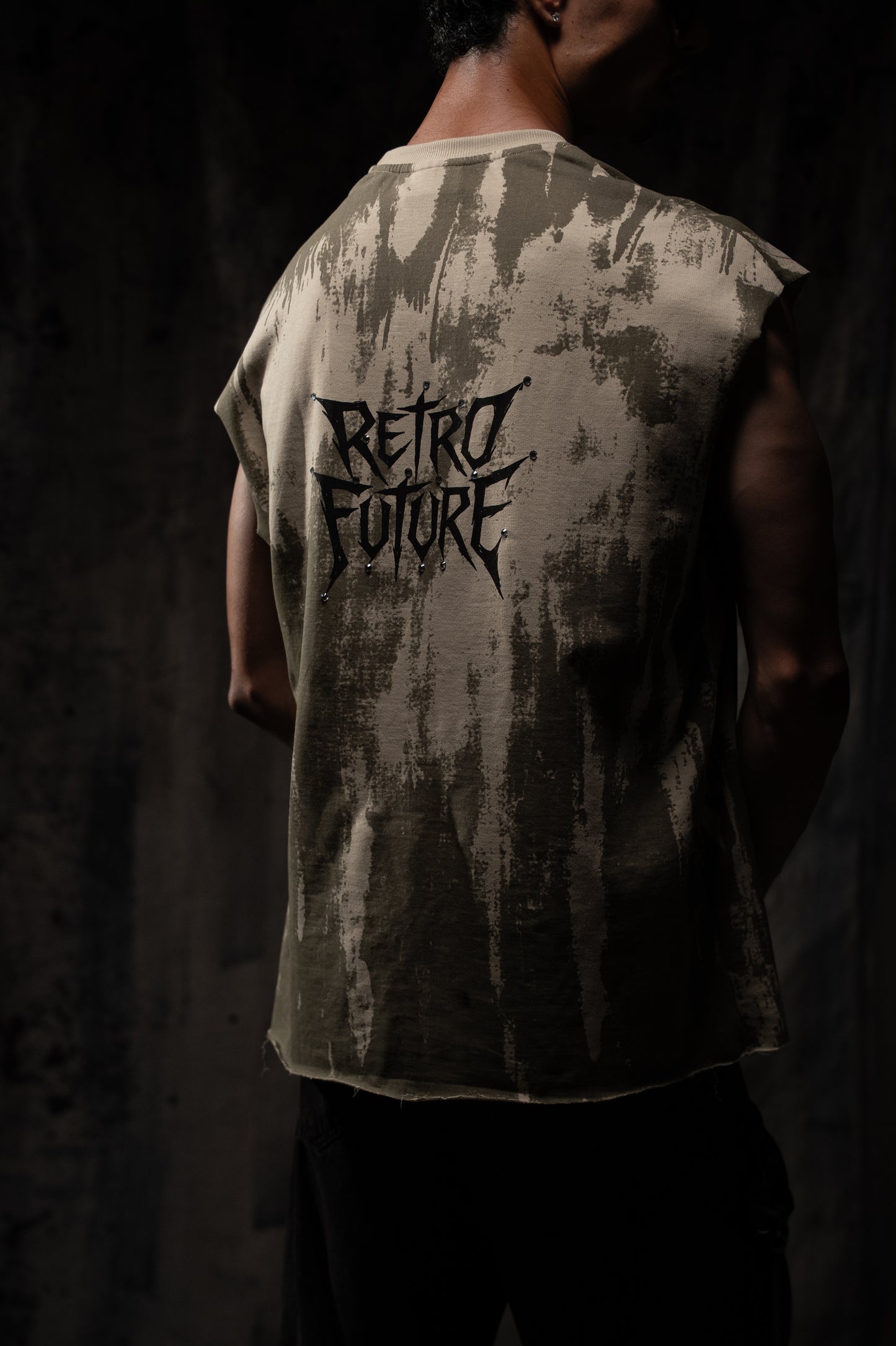Person wearing a sleeveless shirt with 'Retro Future' text on the back against a dark background