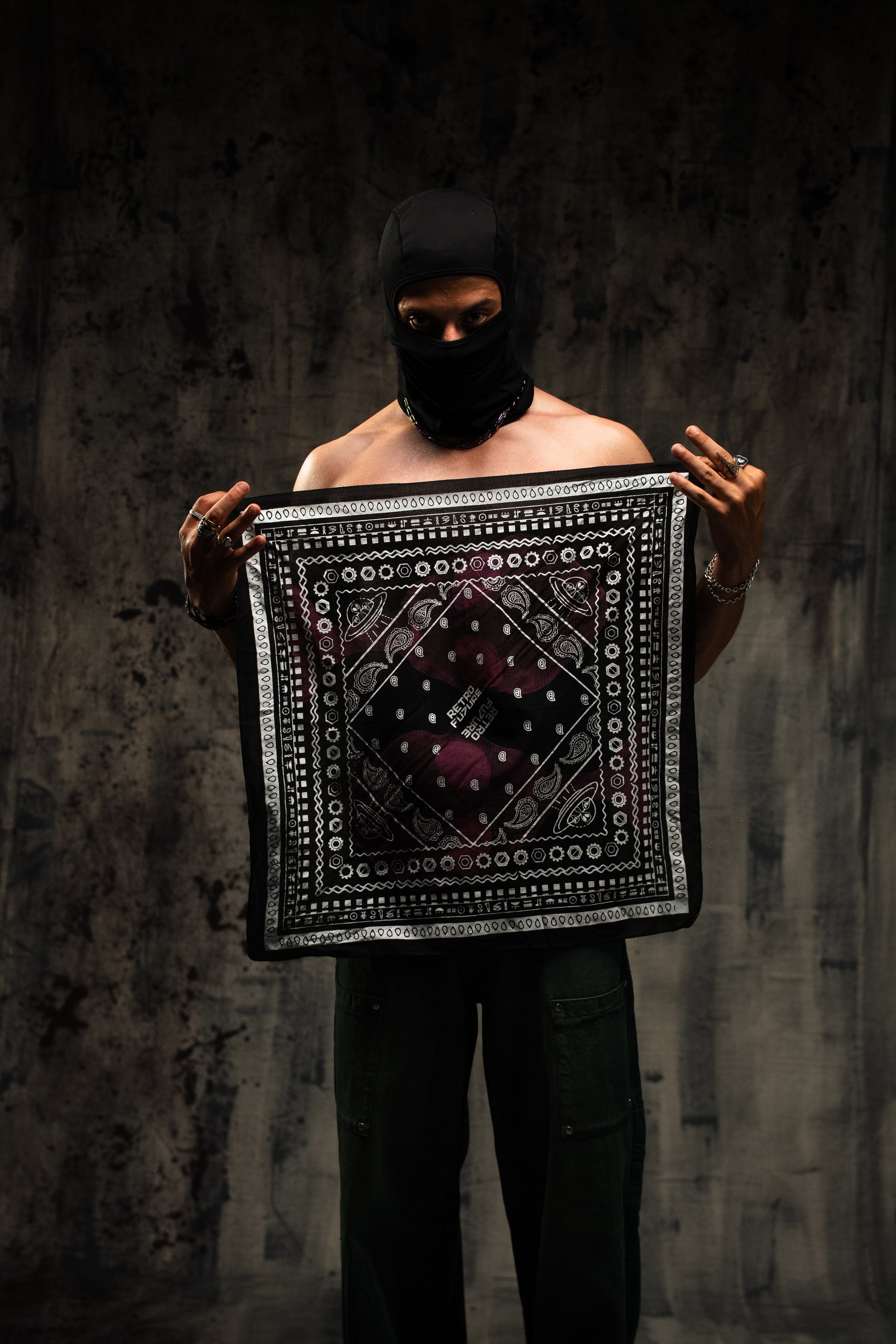 Person holding a patterned fabric against a dark background