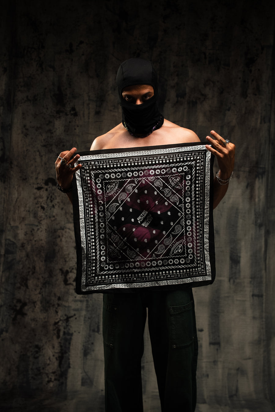 Person holding a patterned fabric against a dark background